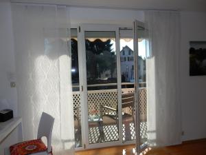 Zimmer mit einer offenen Tür zu einem Balkon in der Unterkunft Ferienwohnung Stiefel mit Garage | Parkplatz in Wangen im Allgäu