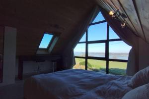 Schlafzimmer mit einem Bett und Meerblick in der Unterkunft Large farmhouse with garden and sea view for 8 people in Locquénolé