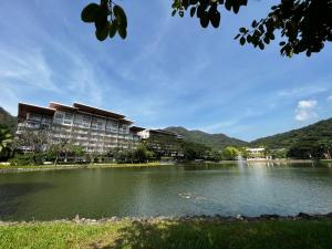 a building next to a lake with mountains in the background at Bonel condo at Pico de Loro in Cutad