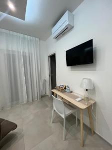 Habitación con escritorio y TV en la pared. en Campione 5 en Bari