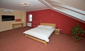 a bedroom with a bed and a red wall at U Hołosia in Osowiec