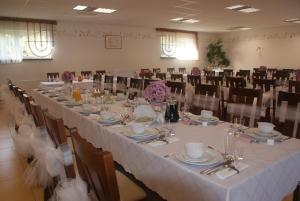un salón de banquetes con una mesa larga y sillas en U Hołosia en Osowiec