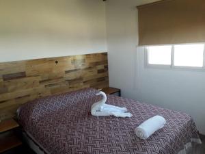 Un dormitorio con una cama con un cisne. en Cabañas Atardecer en Victoria en Victoria