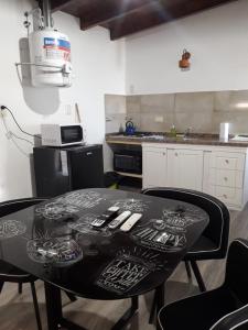 a black table in a kitchen with chairs and a counter at Cabañas Atardecer en Victoria in Victoria