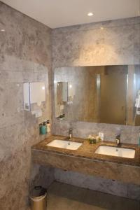 a bathroom with two sinks and a large mirror at 5 yıldızlı Dedeman’da özel residence dairesi in Kocaeli