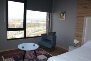 sypialnia z łóżkiem, krzesłem i stołem w obiekcie 5 yıldızlı Dedeman’da özel residence dairesi w mieście Kocaeli