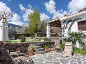 eine Terrasse mit 2 Stühlen und ein Haus in der Unterkunft Casa de Alguaztar in Bubión