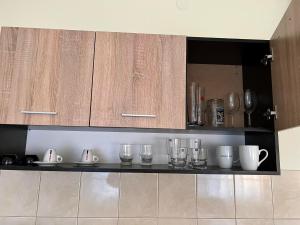 a kitchen with wooden cabinets and glasses on a counter at Wohnung 18 in Lutherstadt Eisleben