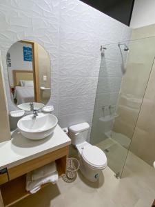 La salle de bains est pourvue de toilettes, d'un lavabo et d'une douche. dans l'établissement SUITES BRISAMAR PLAYA SANTA MARIANITA Manta, à Manta