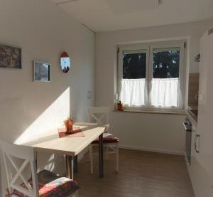 a dining room with a table and a window at Ferienwohnung Stiefel mit Garage | Parkplatz in Wangen im Allgäu