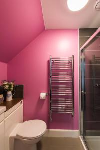 a pink bathroom with a toilet and a shower at The Old Byre with Hot Tub in Forgandenny