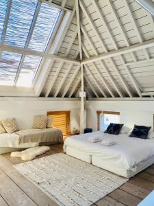 two beds in a room with ceilings with windows at Loft O - River View in Antwerp