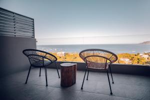 two chairs and a stump in front of a window at Wyndham Tamarindo in Tamarindo