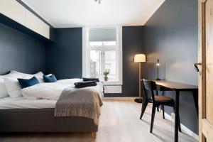 una camera da letto con pareti blu, un letto e una scrivania di Home away from home in Trondheim a Trondheim