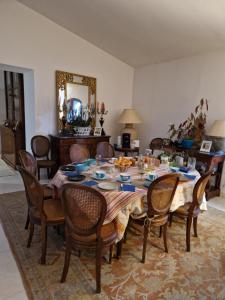 een eetkamer met een tafel en stoelen en een spiegel bij Le Patio Centre ville PEZENAS in Pézenas