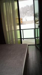 a bedroom with a bed and a large window at snow forest bakuriani apartment eight in Bakuriani