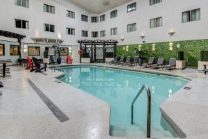 a large pool in a hotel with chairs and tables at Chateau Roberval in Roberval