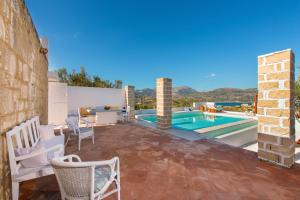 a villa with a swimming pool and a patio at Petra House Karpathos in Karpathos