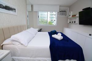 1 dormitorio con 1 cama con 2 toallas en Barra Design - Barra da Tijuca, Piscina e Conforto, en Río de Janeiro
