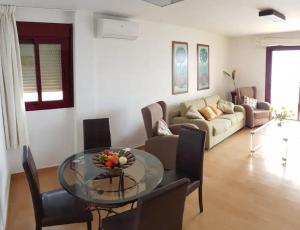 uma sala de estar com uma mesa de vidro e um sofá em Mode's beachfront em Fuengirola