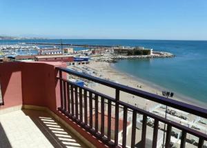 a view of a beach and the ocean from a balcony at Mode's beachfront in Fuengirola