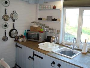a kitchen counter with a sink and a microwave at The Barn - Located away from people! in Swanage