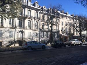 a white building with cars parked in front of it at Les Meublés d'Etigny in Luchon