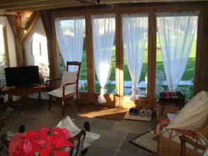 a living room with large windows and a table and chairs at The Barn - Located away from people! in Swanage