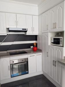 a kitchen with white cabinets and a red apple on the counter at Beautiful & fully renovated flat in historic city center in Quito