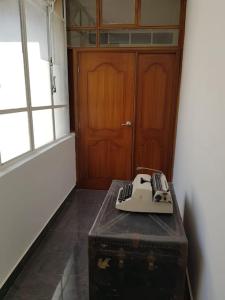 un teléfono en la parte superior de un viejo baúl frente a una puerta en Beautiful & fully renovated flat in historic city center, en Quito