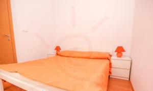 1 dormitorio blanco con 1 cama con manta naranja en Stari Dvori, en Trogir