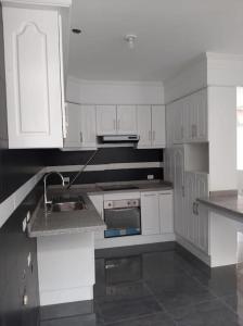 a kitchen with white cabinets and a sink at Beautiful & fully renovated flat in historic city center in Quito