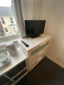 a white desk with a monitor and a computer on it at The Nook En-suite Room in Plymouth
