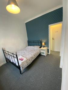 a bedroom with a bed and a green wall at The Nook En-suite Room in Plymouth