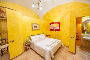 ein Schlafzimmer mit einem Bett in einem gelben Zimmer in der Unterkunft B&B Palazzo de Matteis in San Severo