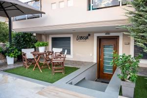 a patio with a table and chairs in front of a house at Lobelia Nafplio Apartments in Nafplio