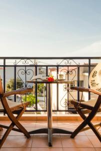 a table and two chairs on a balcony at STUDIOS ATHENA in Megalochori