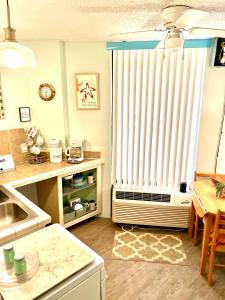 a kitchen with a large window with a radiator at Sandy Feet Retreat - At Symphony Beach Club in Ormond Beach