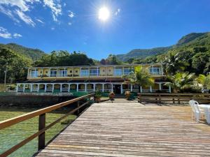 a building on a dock next to the water at Pousada do Preto in Praia do Bananal