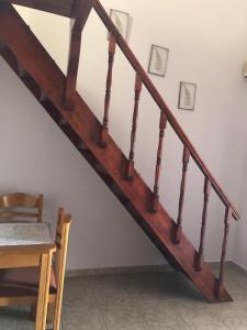 a wooden staircase in a room with a table and chairs at STUDIOS ATHENA in Megalochori