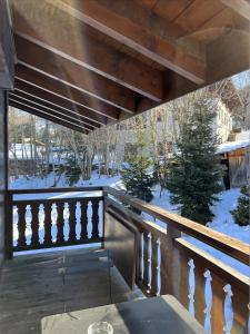 梅傑夫的住宿－N5 Megève - Résidence de L'ours - appart 4 pers，阳台拥有木栏杆和雪覆盖的树木。