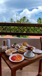 una mesa de madera con platos de comida. en Milos Hotel Icaraizinho, en Icaraí