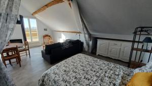 1 dormitorio con cama, sofá y mesa en L'appel de la foret, en Lyons-la-Forêt