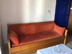 a red couch in the corner of a room at STUDIOS ATHENA in Megalochori
