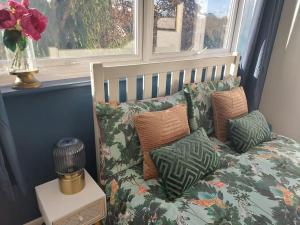 un letto con cuscini sopra in una stanza con finestra di 2 bed flat, Bounds Green, Piccadilly line, London N11 a Londra