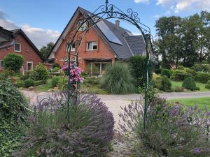 a garden with purple flowers in front of a house at Feldjahns-Ferienwohnung in Ahaus