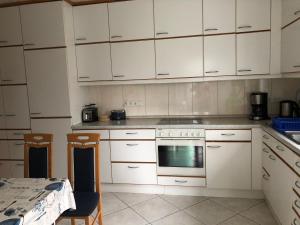 a white kitchen with white cabinets and a table at Feldjahns-Ferienwohnung in Ahaus