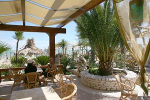 two women sitting at a table in a resort patio at Oasi Beach Hotel in Vieste
