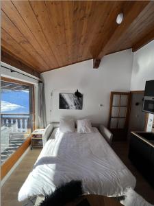 sypialnia z dużym łóżkiem i dużym oknem w obiekcie N5 Megève - Résidence de L'ours - appart 4 pers w mieście Megève