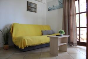 um sofá amarelo numa sala de estar com uma mesa em Apartman Štefanija em Selce